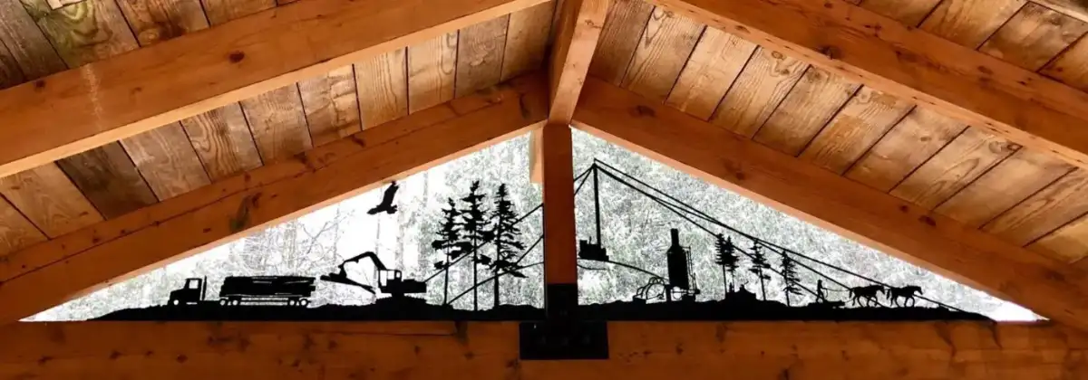 Laser-cut steel panel in a timber gable showing the history of BC logging